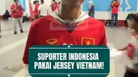 Pemandangan unik terlihat di Stadion Pakansari saat laga Timnas Indonesia melawan Kamboja. Seorang suporter Garuda mencuri perhatian karena mengenakan jersey Timnas Vietnam di tengah dominasi warna merah pendukung Indonesia.