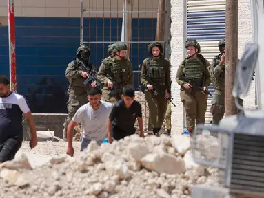 Tentara Israel berjaga-jaga ketika warga Palestina meninggalkan rumah-rumah mereka yang dijadwalkan akan dihancurkan di kamp pengungsi Tulkarem pada 26 Mei 2025. (Jaafar ASHTIYEH/AFP)
