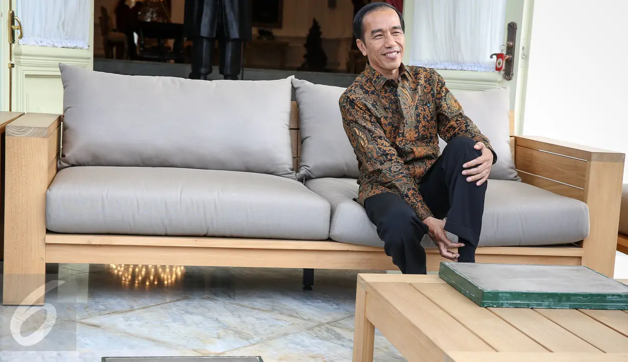 Presiden Joko Widodo melepaskan kaos kakinya untuk melakukan proses pencetakan kaki di Istana Merdeka, Jakarta, Selasa (13/10/2015). Cetakan tersebut akan diletakkan di Taman Pintar Yogyakarta. (Liputan6.com/Faizal Fanani)