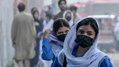 Para siswi sekolah yang mengenakan masker tiba di sebuah sekolah di tengah kondisi kabut asap di Lahore pada Senin 4 November 2024. (Arif ALI/AFP)