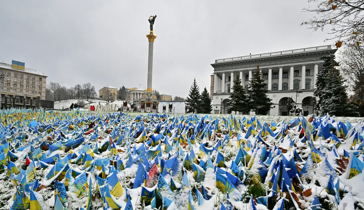 Bendera Ukraina yang melambangkan kematian tentara Ukraina dalam konflik tertutup salju pertama yang turun musim ini di Lapangan Kemerdekaan, Kiev, Ukraina, 17 November 2022. Salju pertama musim ini turun di tengah invasi Rusia ke Ukraina. (Sergei SUPINSKY/AFP)