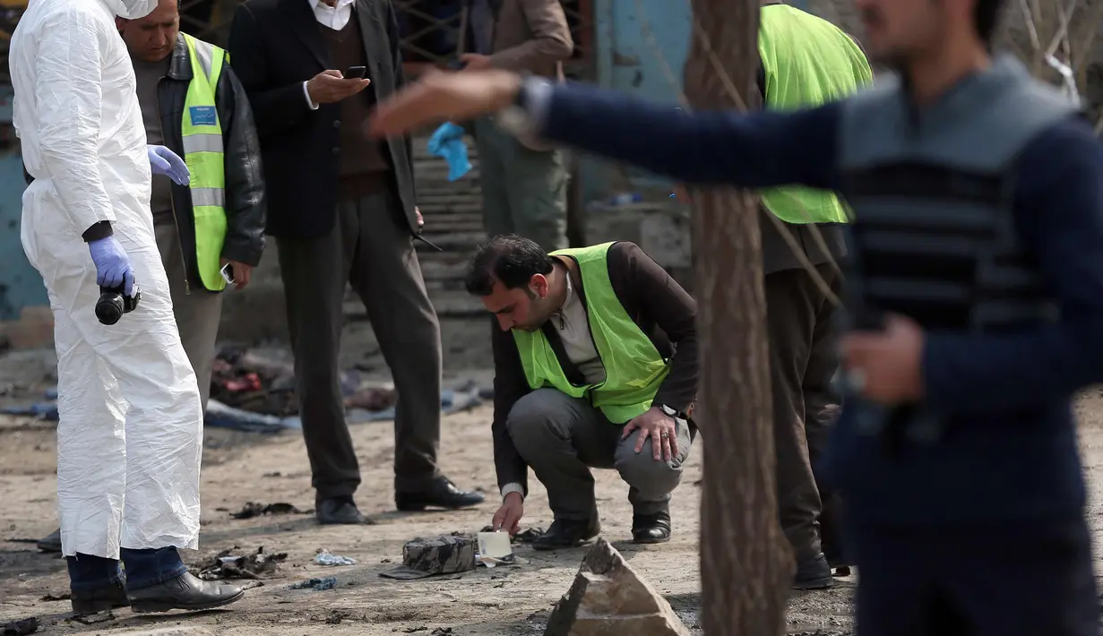 Petugas memeriksa lokasi serangan bom bunuh diri di daerah Syiah di Kabul (9/3). Seorang pembom bunuh diri yang menargetkan kelompok minoritas Afghanistan, Hazaras, meledakkan dirinya di sebuah pos pemeriksaan polisi. (AP Photo / Massoud Hossaini)
