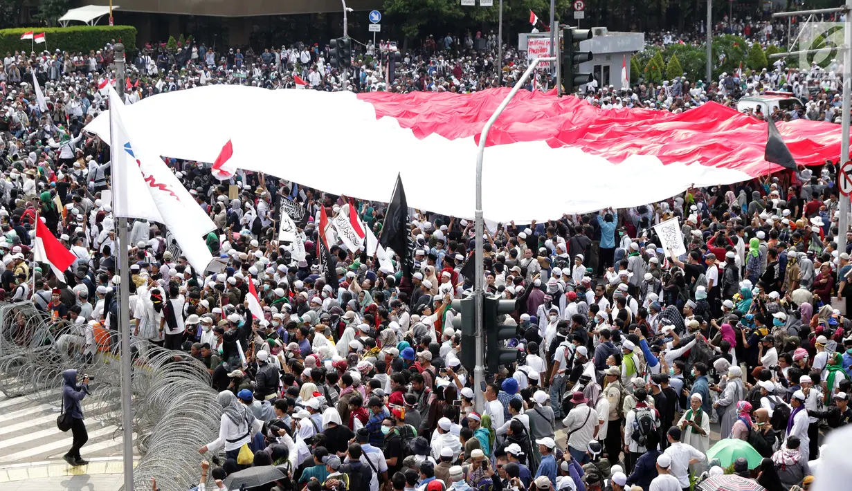 Peserta aksi massa Gerakan Nasional Kedaulatan Rakyat mengibarkan bendera Merah Putih raksasa saat melakukan unjuk rasa di perempatan dekat Gedung Bawaslu, Jakarta, Rabu (22/5/2019). Dalam aksinya, mereka meminta Bawaslu memeriksa kembali hasil Pemilu 2019. (Liputan6.com/Helmi Fithriansyah)