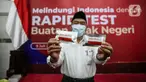 Menko PMK Muhadjir Effendy menunjukkan produk tes cepat Covid-19 di Kantor Kemenko PMK, Jakarta, Kamis (9/7/2020). Pemerintah RI Melalui Kemenko PMK bersama sejumlah kementerian dan lembaga terkait meluncurkan produk tes cepat Covid-19. (Liputan6.com/Faizal Fanani)