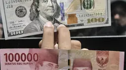 Pegawai menunjukkan uang pecahan 100 USD di salah satu gerai money changer di Jakarta, Senin (4/7/2022). Melansir data Refinitiv, hingga 4 Juni 2022 pukul 11:10 WIB rupiah melemah 0,15 persen ke Rp14.957 per USD 1. (merdeka.com/Iqbal S Nugroho)