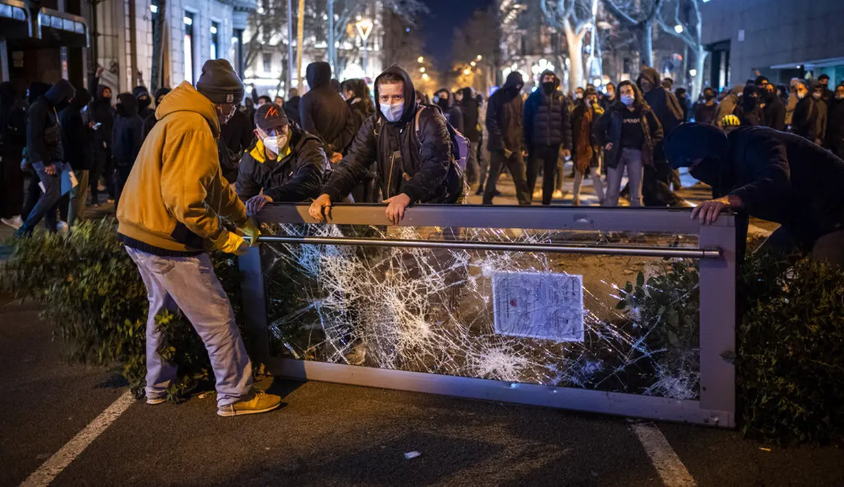 Demonstran membuat barikade saat bentrok dengan polisi dalam protes penangkapan rapper Pablo Hasel di Barcelona, Spanyol, Selasa (16/2/2021). Pablo Hasel menggambarkan kasusnya sebagai perjuangan untuk kebebasan berbicara. (AP Photo/Emilio Morenatti)