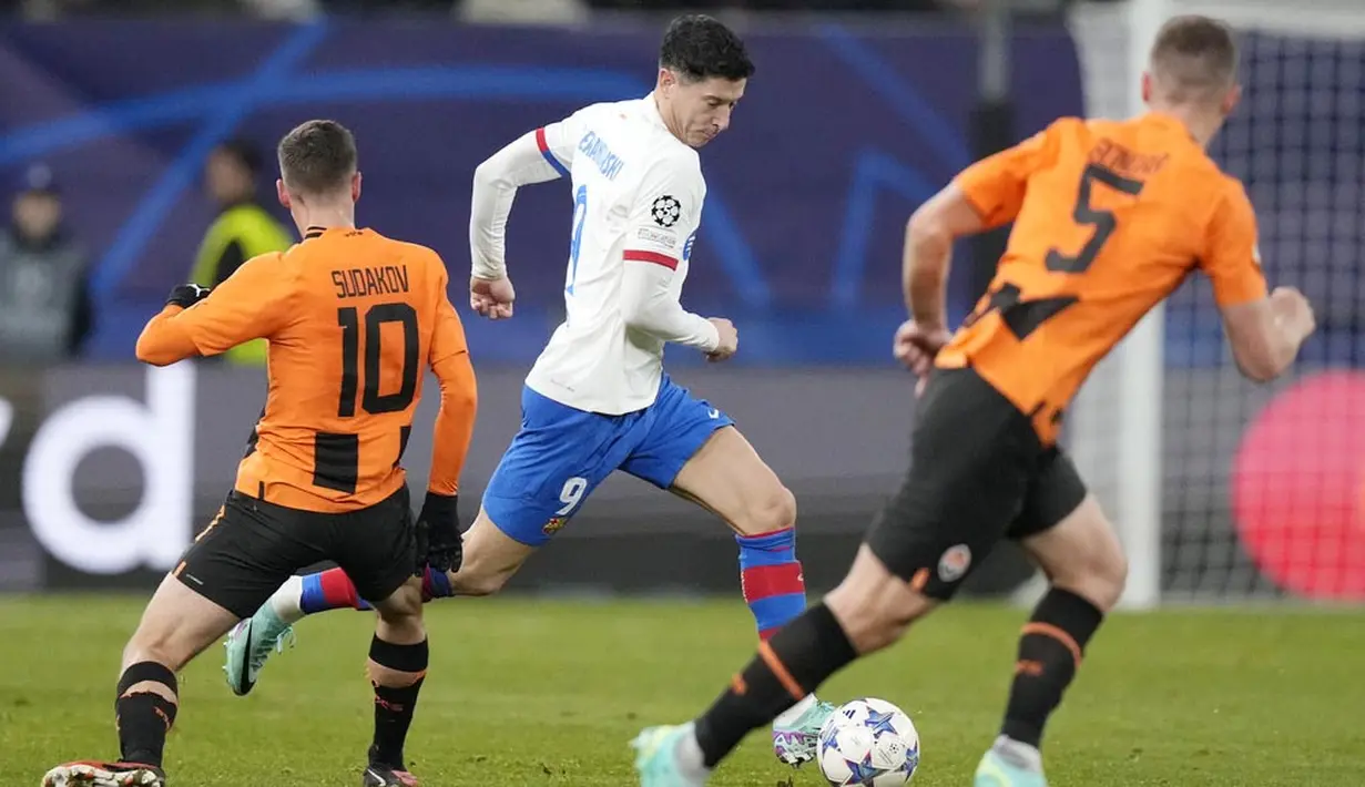 Pemain Barcelona, Robert Lewandowski, berusaha melewati pemain Shakhtar Donetsk dalam duel matchday 4 Grup H Liga Champions 2023/2024 di Volksparkstadion, Hamburg, Rabu (8/11/2023). (AP Photo/Matthias Schrader)