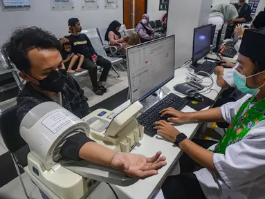Warga melakukan pengukuran tensi darah di Puskesmas Kebayoran Lama, Jakarta, Jumat (9/1/2026). Pelayanan kesehatan di Puskesmas Kebayoran Lama, sempat menarik perhatian Gubernur DKI Jakarta, Pramono Anung. (merdeka.com/Arie Basuki)