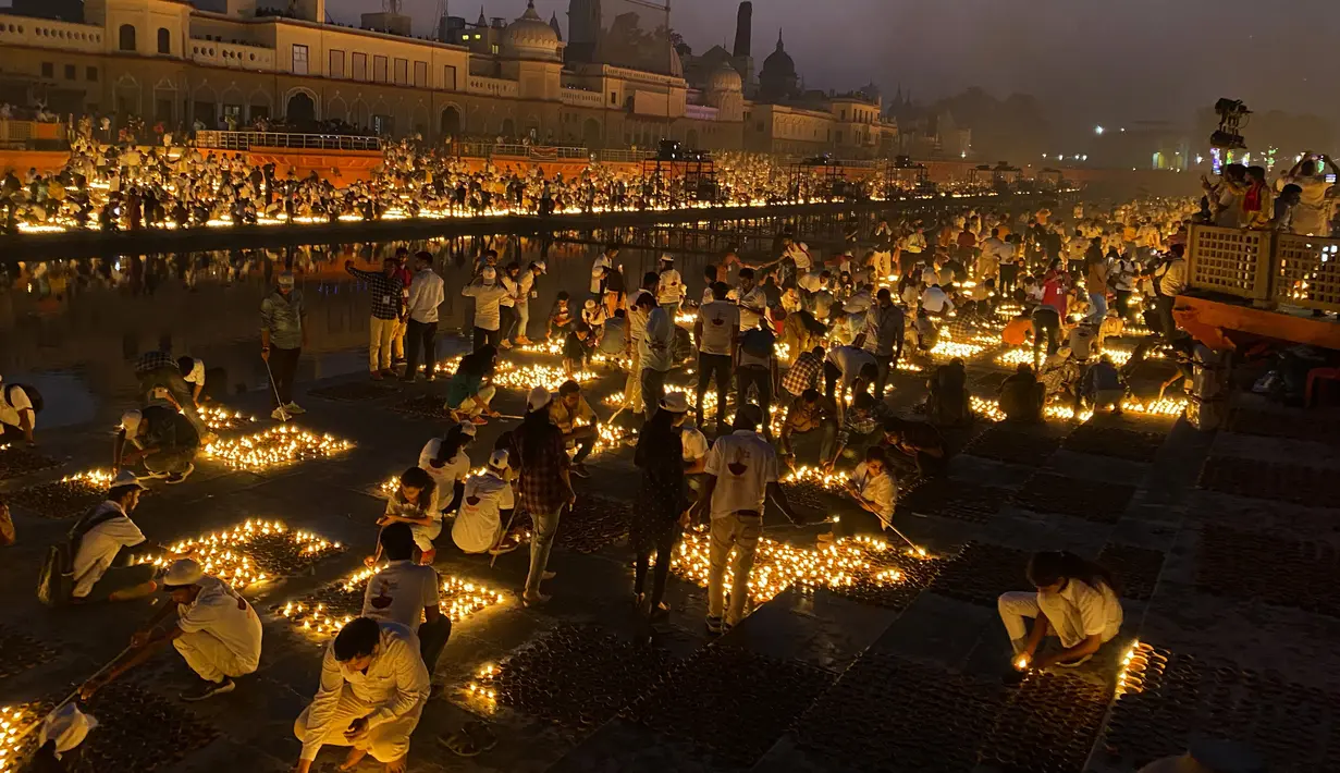 Orang-orang menyalakan lampu di tepi sungai Saryu di Ayodhya, India, Rabu (3/11/2021). Lebih dari 900.000 lampu minyak dinyalakan dan terus menyala selama 45 menit saat kota Ayodhya mempertahankan Rekor Dunia Guinness sebagai bagian dari perayaan festival Diwali. (AP Photo/Rajesh Kumar Singh)