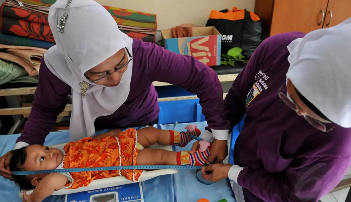 Relawan tampak menimbang dan mengukur seorang balita di posyandu Gerogol Selatan, Kebayoran Lama, Jakarta, Selasa (29/4/14) (Liputan6/JohanTallo)