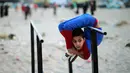 Mohammed al Sheikh menunjukkan kemampuannya di sebuah pantai di Kota Gaza, Palestina, Kamis (2/6). Dengan tinggi 1,6 meter dan berat 29 kg, Mohammed mampu menekukan tubuhnya dengan posisi yang menurut kita mustahil untuk dilakukan (REUTERS/Mohammed Salem)