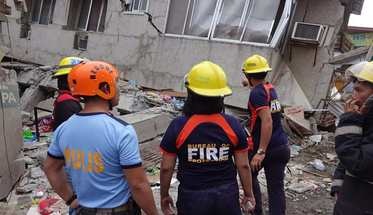 Tim penyelamat memeriksa bangunan yang rusak setelah gempa bumi yang melanda Padada, provinsi Davao del Sur, Filipina selatan (15/12/2019). Gempa tersebut berkekuatan Magnitudo 6,9. (AP Photo)