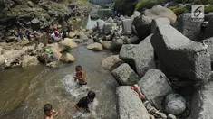 Anak-anak bermain pada kubangan air yang tersisa di kawasan Bendungan Katulampa, Bogor (15/7). Musim kemarau menyebabkan Bendungan Katulampa berada di titik nol berdampak pada sumur-sumur warga di sekitar mengalami kekeringan. (Merdeka.com/Arie Basuki)