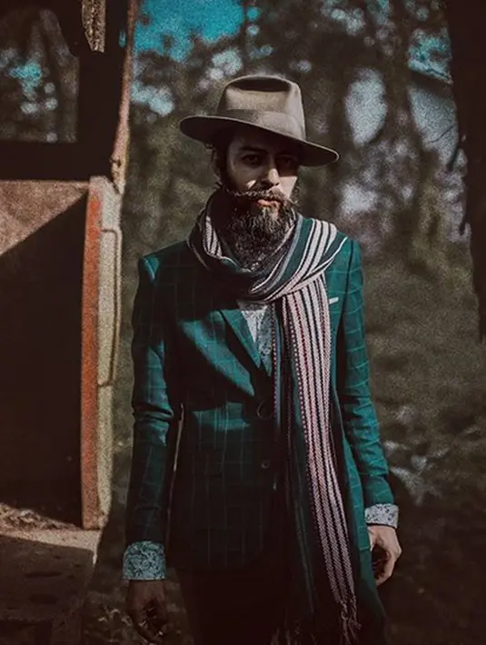 Di foto ini, Alex berbusana formal dengan setelan jas hijau bermotif kotak-kotak. Mempertahankan gaya nyentriknya, Alex tetap memadukan dengan kemeja bermotif bunga-bunga dan scarf luriknya. (Instagram/alexabbad)