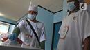 Petugas menggunakan atribut dokter saat Pilkada Depok di Tempat Pemungutan Suara (TPS) 56, Mekarjaya, Depok, Rabu (9/12/2020). TPS dengan tema kesehatan itu bertujuan menarik warga menggunakan hak pilih dan mengingatkan protokol kesehatan di masa Pandemi COVID-19.  (Liputan6.com/Herman Zakharia)
