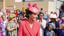 Kate Middleton, Duchess of Cambridge dari Inggris berbicara kepada para tamu di Pesta Taman Kerajaan di Istana Buckingham di London (18/5/2022). Kate Middleton memilih gaun mantel Emilia Wickstead versi koral yang telah ia kenakan pada beberapa kesempatan sebelumnya. (AFP/Pool/Dominic Lipinski)