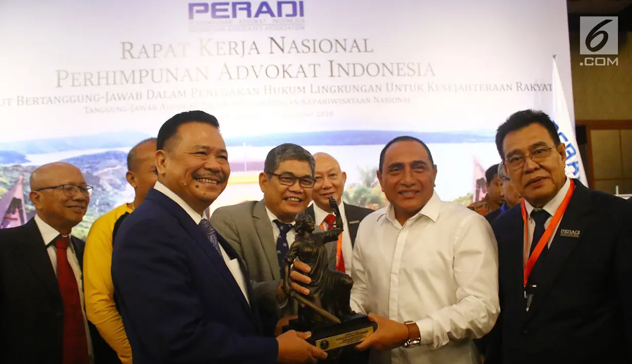 Gubernur Sumut Edy Rahmayadi (kedua kanan) menerima cenderamata dari Ketua Dewan Pembina DPN Perhimpunan Advokat Indonesia (Peradi) Otto Hasibuan (kedua kiri) ketika Rapat Kerja Nasional (Rakernas) Peradi di Medan, Kamis (6/12). (Liputan6.com/HO/Djoko)