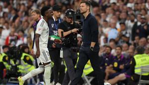 Penyerang Real Madrid asal Brasil #07, Vinicius Junior, berjalan melewati pelatih Real Madrid asal Spanyol, Xabi Alonso, saat ia digantikan dalam pertandingan Liga Spanyol antara Real Madrid CF dan FC Barcelona di Stadion Santiago Bernabeu, Madrid, pada 26 Oktober 2025. (Oscar DEL POZO/AFP)