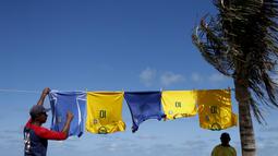 Para pedagang kaki lima menjual jersey timnas Brasil di sekitar stadion Arena Fonte Nova, Salvador, Brasil. (AP/Natacha Pisarenko)