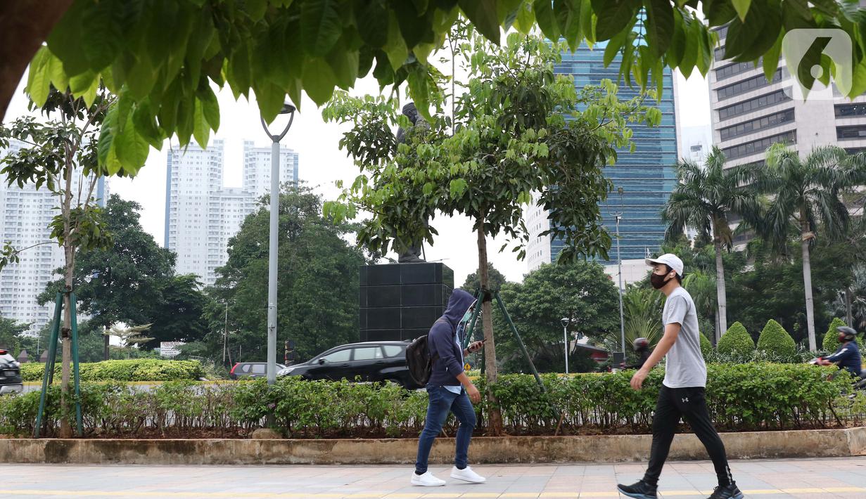 Warga mengenakan masker berjalan di pedestrian Jalan Jenderal Sudirman, Jakarta, Kamis (5/11/2020). BPS mencatat ekonomi Indonesia pada kuartal III-2020 minus 3,49 persen, Indonesia dipastikan resesi karena pertumbuhan ekonomi dua kali mengalami minus. (Liputan6.com/Helmi Fithriansyah)