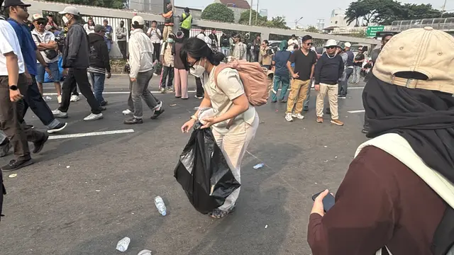 Sisi memunguti sampah di tengah demonstrasi. (Liputan6.com/Ady Anugrahadi)