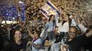 Warga Israel merayakan pelantikan pemerintahan baru di Tel Aviv, Israel, Minggu, 13 Juni 2021. Naftali Bennett, mantan sekutu Benjamin Netanyahu menjadi perdana menteri baru Israel. (AP Photo/Oded Balilty)