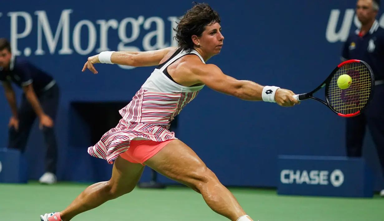 Petenis Spanyol, Carla Suarez Navarro mengembalikan bola Maria Sharapova saat bertanding pada 16 besar AS Terbuka 2018 di New York, (3/9). Sharapova kalah dua set langsung 6-4, 6-3. (AFP Photo/Eduardo Munoz Alvarez)