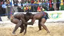 Kouame Roumaric dari Burkinabe (kanan) bertarung dengan Mouhamet Bousso dari Senegal dalam kategori 120 kg Final Gulat Wanita Tradisional selama Francophonie ke-8 di Treichville Sports Park di Abidjan pada 29 Juli 2017. (AFP Photo/Sia Kambou)