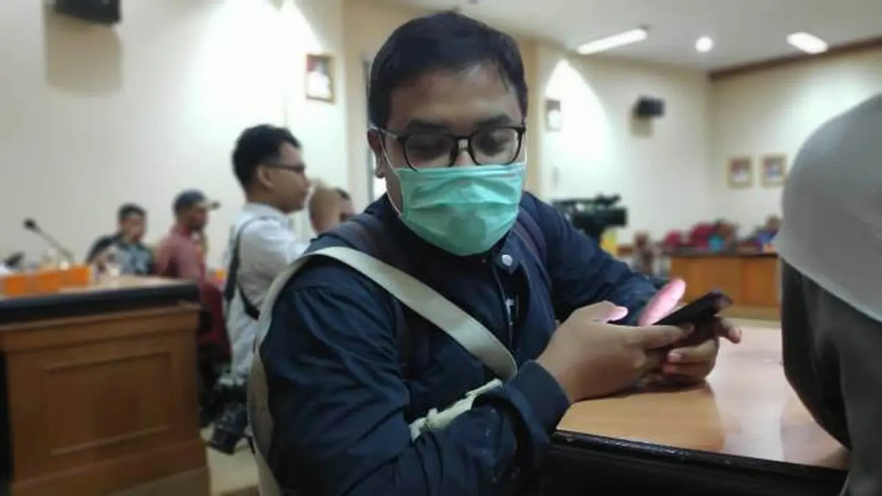 Seorang warga Pekanbaru memakai masker sebagai antisipasi tidak terserang penyakit.