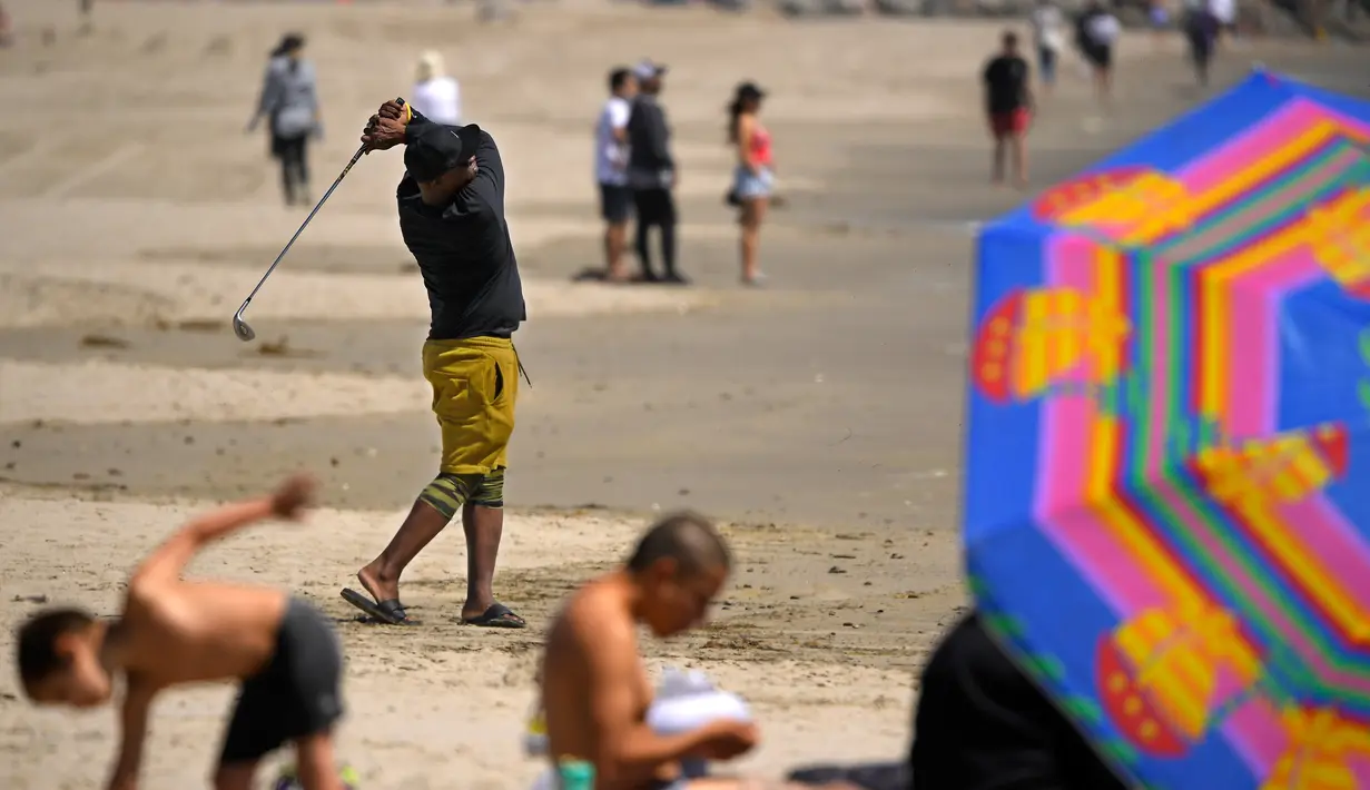Seorang pria bermain golf di Pantai Venice, Los Angeles (13/5/2020). Los Angeles County membuka kembali pantai-pantainya pada Rabu dalam pelonggaran terbaru pembatasan coronavirus yang telah menutup sebagian besar ruang publik dan bisnis California selama hampir dua bulan. (AP/Mark J. Terrill)