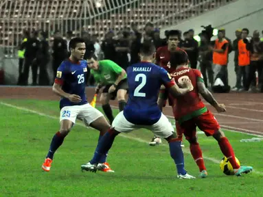 Pemain malaysia, Mahali (tengah) berusaha mengambil bola dari kawalan Pemain Indonesia, Irfan Bachdim (kiri) dalam Laga Piala AFF Suzuki 2012 antara Malaysia vs Indonesia di Stadion Bukit Jalil, Kuala Lumpur, Malaysia. pertandingan berakhir dengan skor 2-