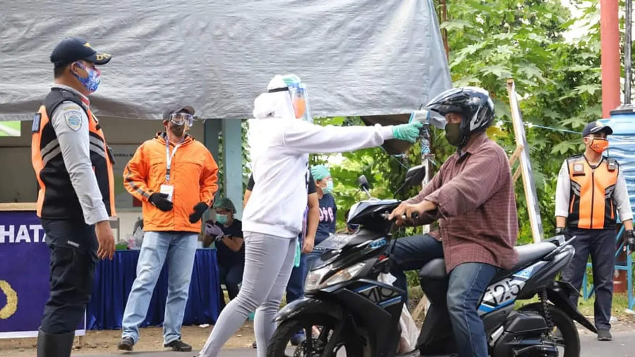 Pemeriksaan suhu tubuh untuk warga yang akan masuk ke wilayah Kota Manado.