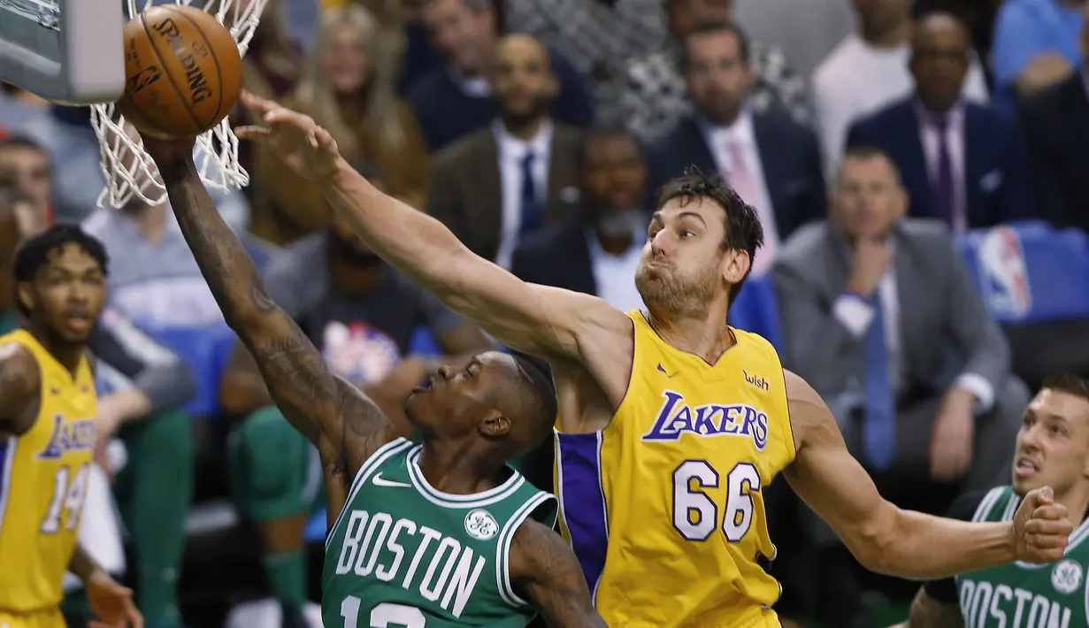Pemain Boston Celtics, Terry Rozier (depan) memasukan bola saat diadang pemain Los Angeles Lakers, Andrew Bogut pada laga NBA basketball game di TD Garden, Boston, (8/11/2017). Celtics menang 107-96. (AP/Winslow Townson)