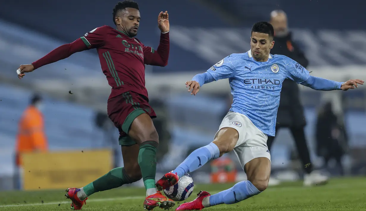 Bek Wolverhampton Wanderers, Nelson Semedo berusaha melewati bek Manchester City, Joao Cancelo pada pertandingan lanjutan Liga Inggris di stadion Etihad di Manchester, Inggris, Rabu (3/3/2021). City menang atas Wolves 4-1. (Clive Brunskill/Pool via AP)