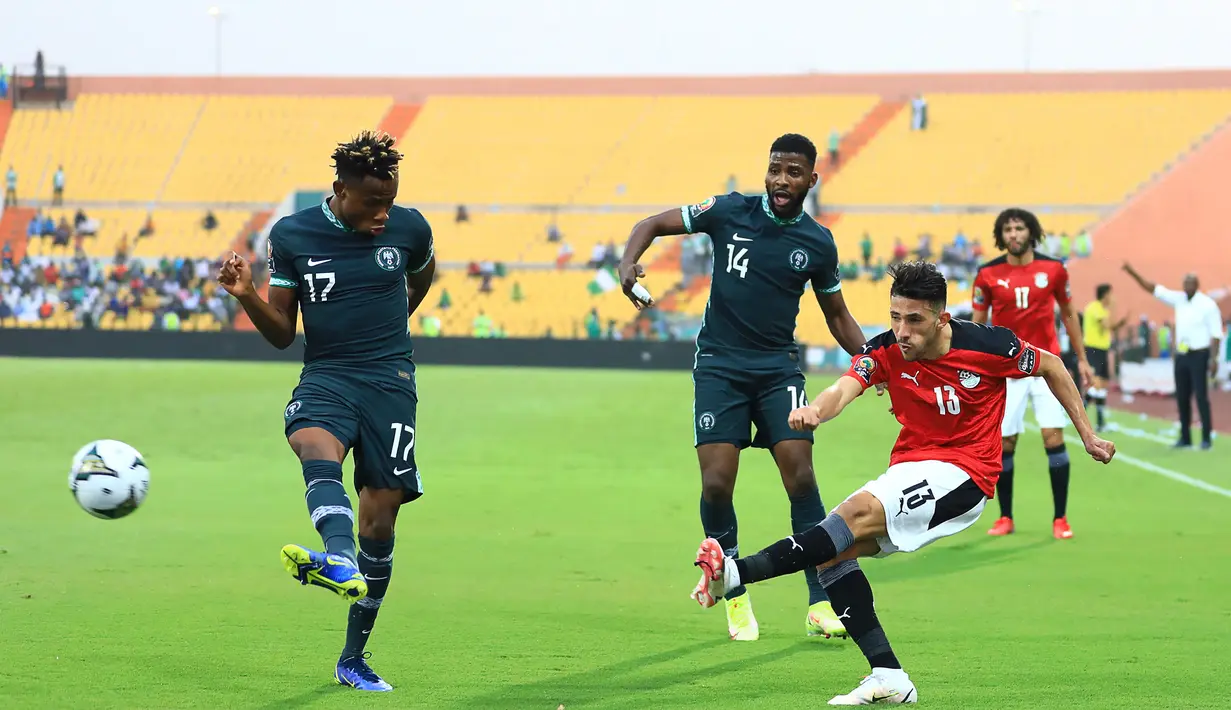 Bek Mesir, Ahmed Abou el Fotouh (kanan) mengumpan bola dari kawalan pemain Nigeria, Samuel Chukwueze (kiri) dan pemain depan Nigeria Kelechi Iheanacho (tengah) pada pertandingan Grup D Piala Afrika (CAN) 2021 di Stade Roumde Adjia di Garoua (12/1/2022). (AFP/Daniel Beloumou Olomo)