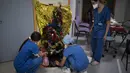 Pekerja rumah sakit meletakkan hadiah di bawah pohon natal di unit perawatan intensif COVID-19 di rumah sakit la Timone di Marseille, Prancis selatan, Jumat (24/12/2021). (AP Photo/Daniel Cole)