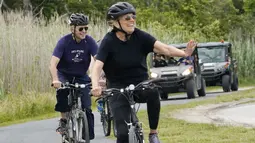 Presiden Joe Biden bersama ibu negara, Jill Biden bersepeda di Pantai Rehoboth, Delaware, Kamis (3/6/2021). Mereka bersepeda sekaligus untuk merayakan ulang tahun ke-70 ibu negara Amerika Serikat. (AP Photo/Susan Walsh)