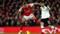 Oleksandr Zinchenko berduel melawan Antony dalam laga Arsenal versus Manchester United di Emirates Stadium, London, Minggu (22/1/2023). (AP/Ian Walton)