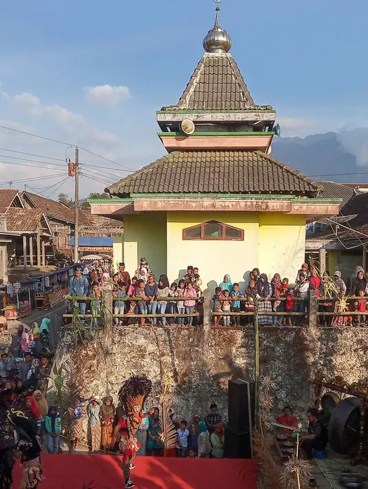 Warga menyaksikan aksi tarian kuda lumping para penari komunitas lima gunung di Desa Mantran Wetan, Kabupaten Magelang, Jumat  (11/10/2019). Pertunjukan ini bagian dari Perayaan Saparan sebagai wujud syukur warga di desa itu. (Liputan6.com/Gholib)