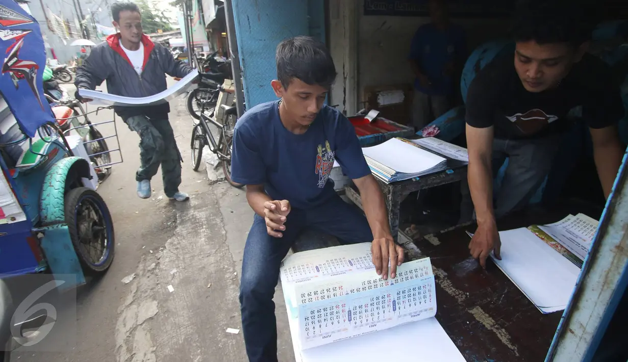 Pekerja menyelesaikan pembuatan kalender 2017 di tempat produksi, kawasan Senen, Jakarta, Selasa (13/12). Menjelang pergantian tahun, pesanan kalender meningkat hingga 50% dengan harga rata-rata Rp6ribu-Rp20ribu per buah. (Liputan6.com/Immanuel Antonius)