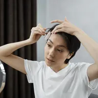 Disarankan untuk memijat beberapa tetes minyak kelapa atau zaitun ke kulit kepala setiap hari sebagai cara merawat rambut beruban. (Foto/dok: Freepik)