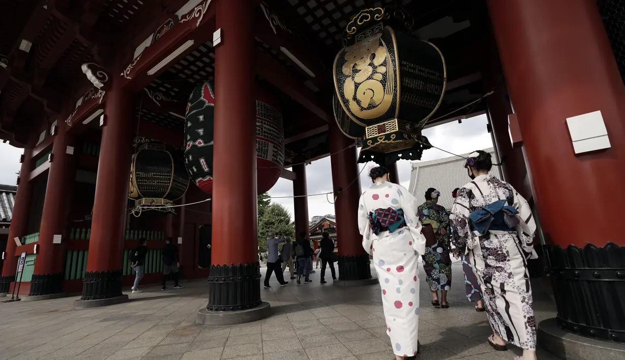 Pengunjung mengenakan kimono berjalan-jalan di distrik Asakusa  di Tokyo, Selasa (29/9/2020). kota Jepang mengonfirmasi lebih dari 200 kasus virus corona pada hari Selasa. (AP Photo/Eugene Hoshiko)