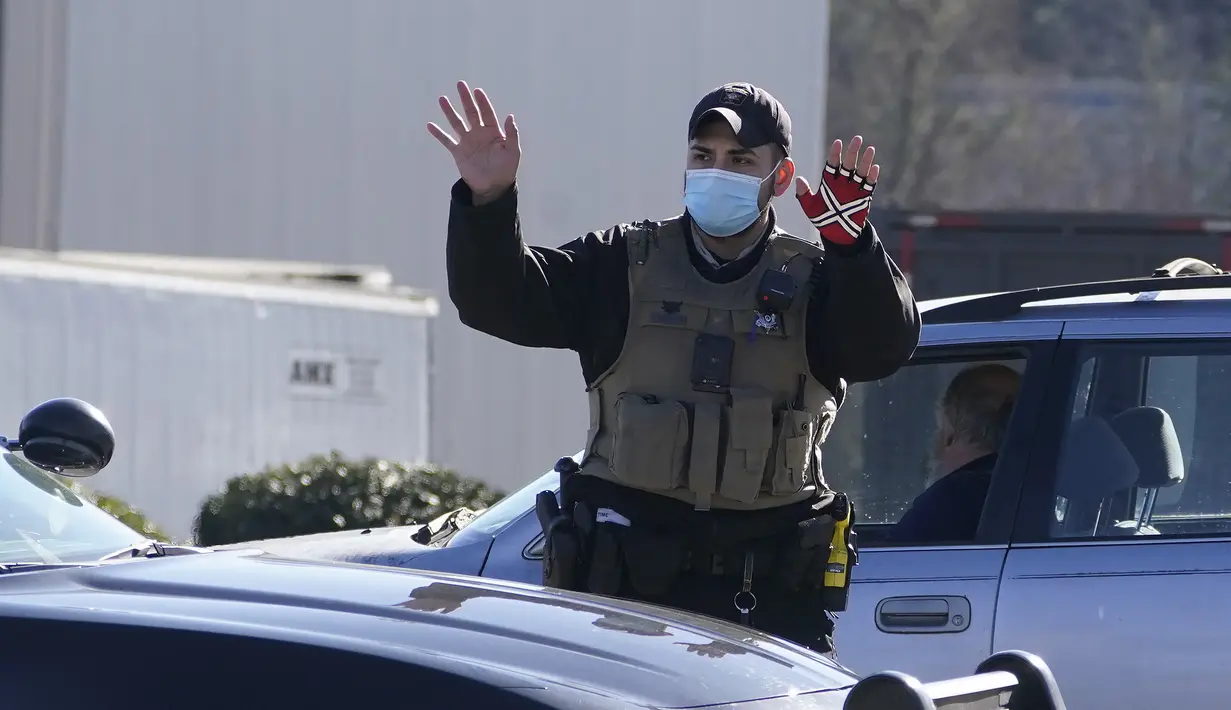 Seorang petugas polisi mengarahkan lalu lintas setelah kebocoran nitrogen cair yang menewaskan enam orang di Prime Pak Foods, sebuah pabrik unggas di Gainesville, Ga., Kamis (28/1/2021). (AP Photo/John Bazemore)