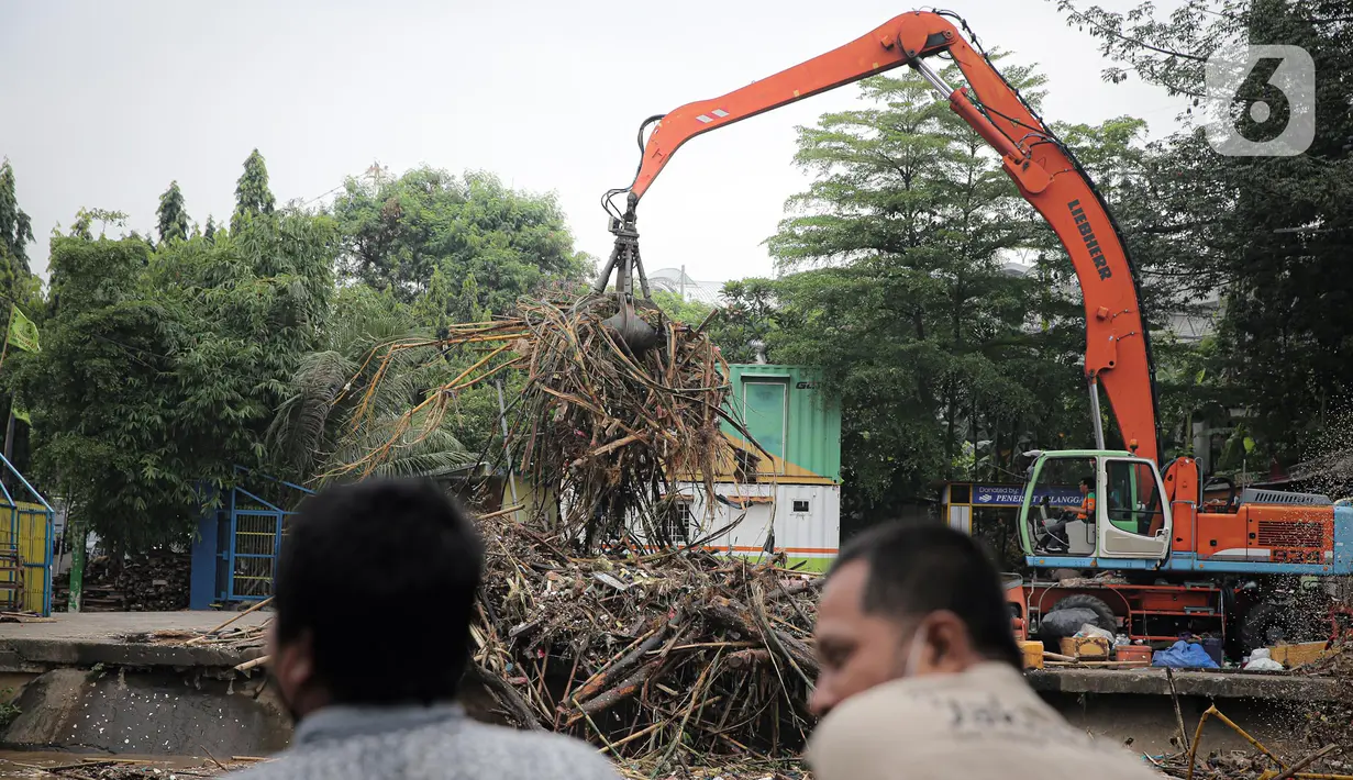 Petugas Dinas Kebersihan DKI Jakarta menggunakan alat berat untuk membersihkan sampah di Pintu Air Manggarai, Jakarta, Senin (10/10/2022). Hujan lebat yang mengguyur wilayah Bogor dan sekitarnya menyebabkan debit air Sungai Ciliwung meningkat dan menghanyutkan sampah ke Pintu Air Manggarai. (Liputan6.com/Faizal Fanani)