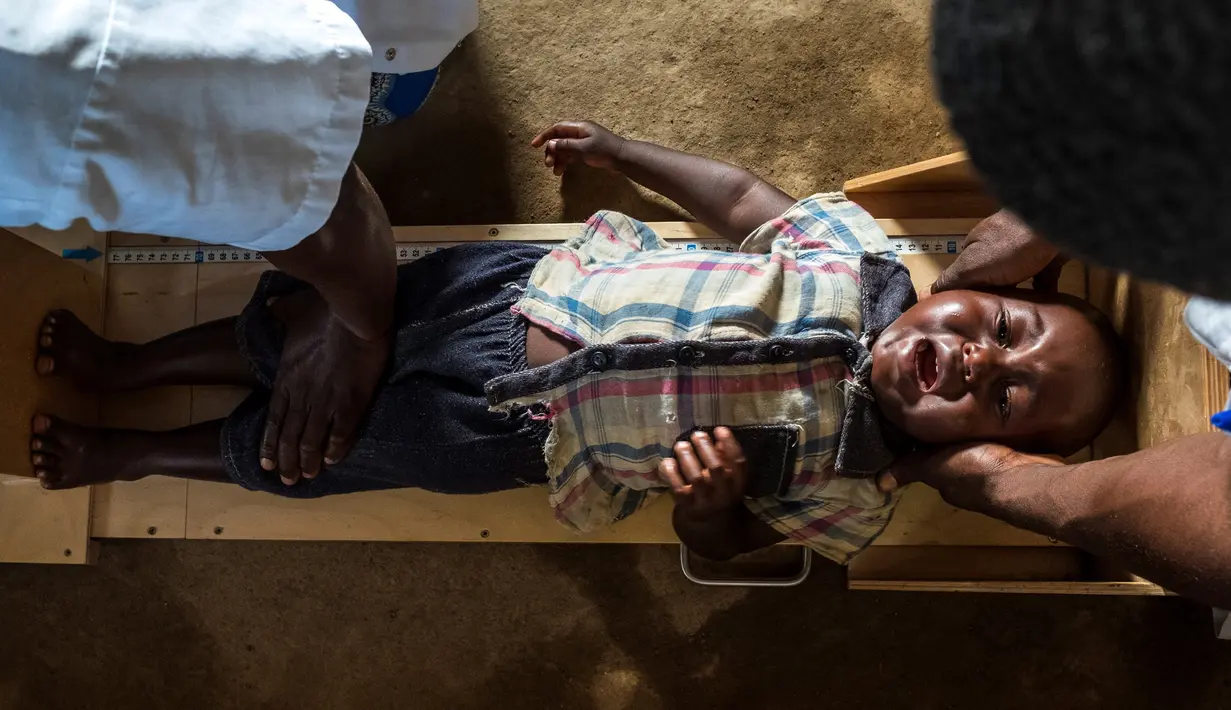 Petugas kesehatan mengukur tinggi badan seoarang anak pada saat program pencegahan kurang gizi yang disponsori oleh World Food Program di Pusat kesehatan di Mbau, Republik Demokratik Kongo (15/11). (AFP/ Eduardo Soteras)