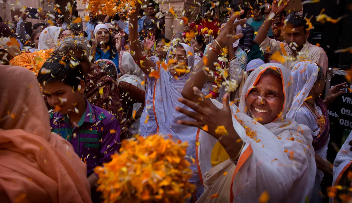 Para janda India melemparkan kelopak bunga saat menghadiri festival holi di kota Vrindavan, India, (9/3). Holi merupakan festival awal musim semi yang ditandai dengan aksi melempar bubuk berwarna-warni. (AP Photo /Manish Swarup)