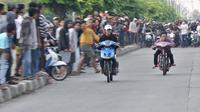 Dua pembalap beradu kecepatan saat ikut dalam balapan liar di Jakarta, Minggu (27/5) pagi. Balapan liar masih menjadi kegiatan favorit remaja di Ibu Kota dalam menghabiskan waktu Minggu pagi di bulan Ramadan. (Merdeka.com/Iqbal S Nugroho)