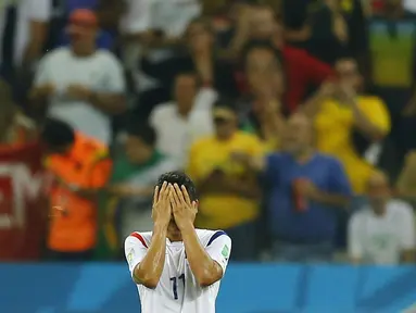 Pemain depan Korea Selatan, Lee Keun-ho, menutup wajah usai dikalahkan Belgia 0-1 di laga penutup penyisihan Piala Dunia Grup H di Stadion Corinthians, Sao Paulo, (27/6/2014). (REUTERS/Ivan Alvarado)
