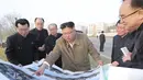 Pemimpin Korea Utara Kim Jong-un memberikan arahan kepada stafnya saat mengunjungi lokasi konstruksi pembangunan gedung apartemen di tepi Sungai Pothong, Korea Utara, Kamis (1//4/2021)..( STR/KCNA VIA KNS/AFP)