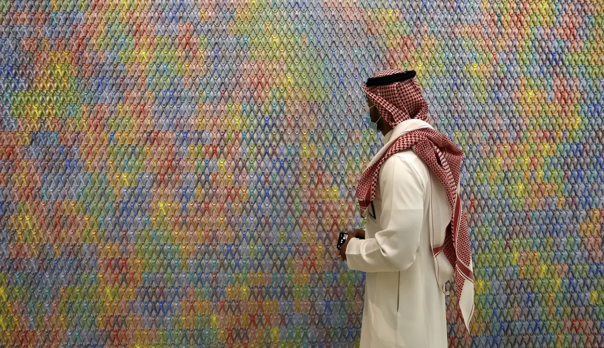Seorang pria Saudi melihat karya seni seniman Korea Do Ho Suh di Pusat Kebudayaan Dunia King Abdulaziz, juga dikenal sebagai Ithra, di Dammam, Arab Saudi, Minggu (27/6/2021).  Pusat ini dibangun oleh Saudi Aramco dan diresmikan oleh Raja Salman pada 2016. (AP Photo/Amr Nabil)